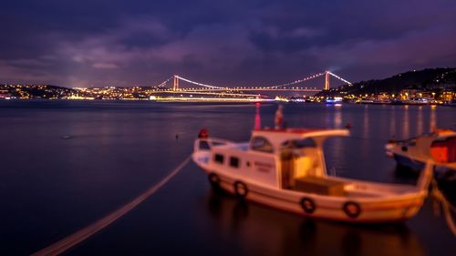 Illuminated bridge over river at night