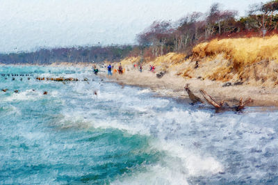 People on sea shore against sky