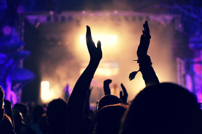 Silhouette people at music concert against sky at night