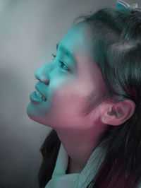 Close-up of smiling young woman looking away at home