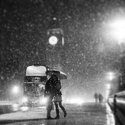Blurred motion of woman walking on road at night
