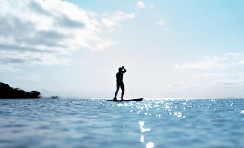 Man surfing in sea against sky