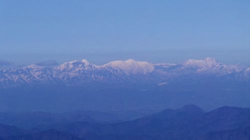 Scenic view of snowcapped mountains against blue sky