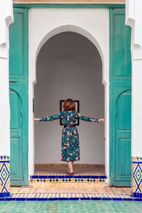 Rear view of woman standing at entrance of building