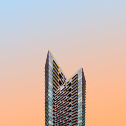 Low angle view of modern building against sky during sunset