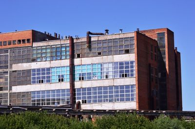 Low angle view of modern building against clear blue sky