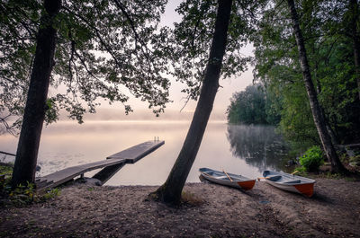 Boats moored on shore against sky