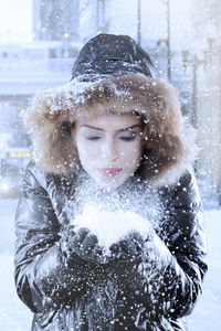 Woman blowing snow during winter