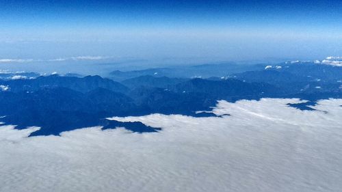 Aerial view of landscape against blue sky