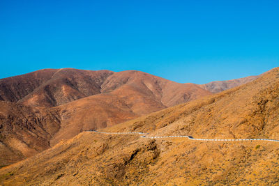 Scenic view of mountains against clear blue sky