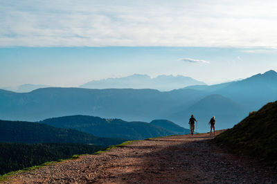 People walking on mountain against sky