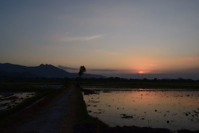 Scenic view of land against sky during sunset