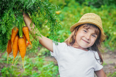 Portrait of young woman standing against plants