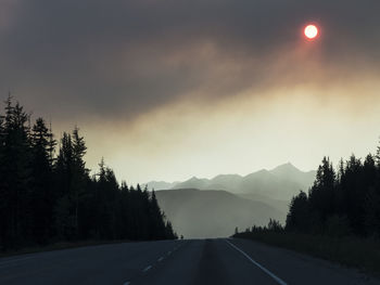 Road amidst trees against sky