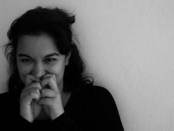 Portrait of woman hands covering mouth against wall