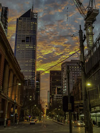 City street and buildings against sky at dusk