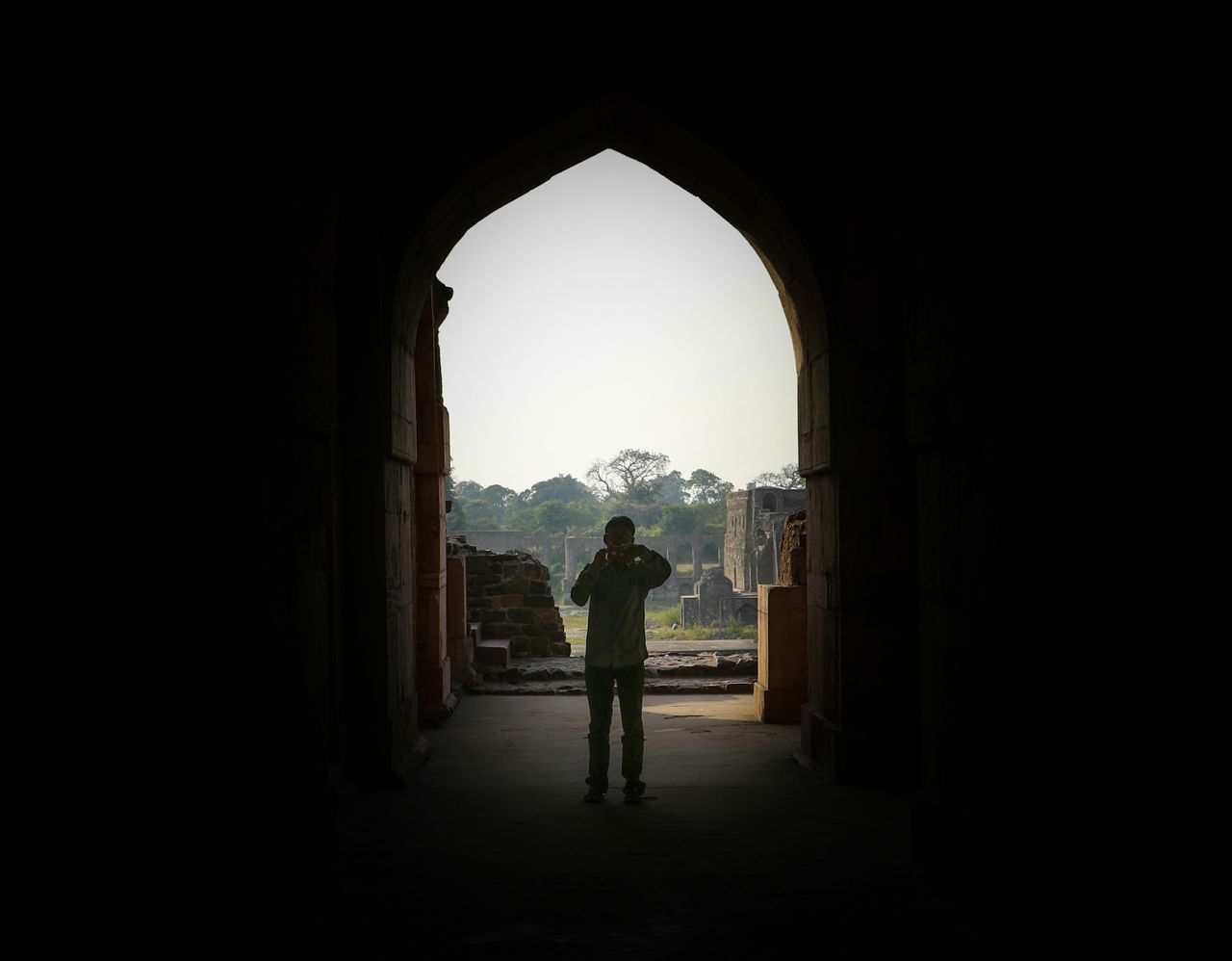 MAN STANDING IN CORRIDOR OF BUILDING