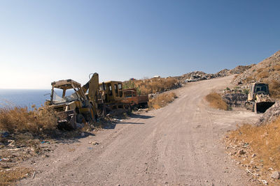 Wrecked and abandoned cars and ships in a remote location in the island