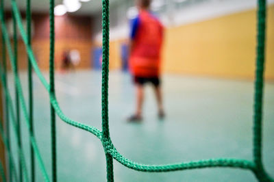 Rear view of sportsperson seen through net