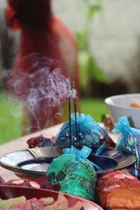Burning incense stick with colorful bag filled with coins
