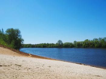 Scenic view of lake against clear blue sky