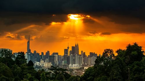 Buildings in city against sky during sunset