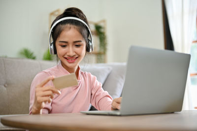 Portrait of young woman using laptop at home