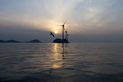 Silhouette ship in sea against sky during sunset