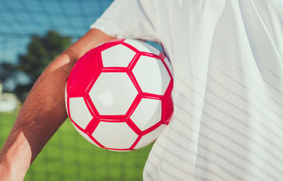 Low section of man holding soccer ball