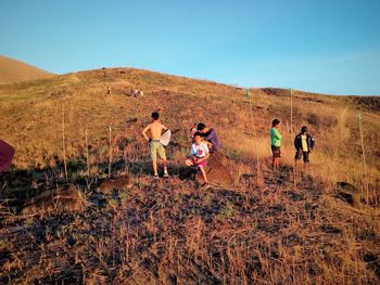 People on landscape against clear sky