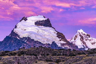 Scenic view of snowcapped mountains against cloudy sky