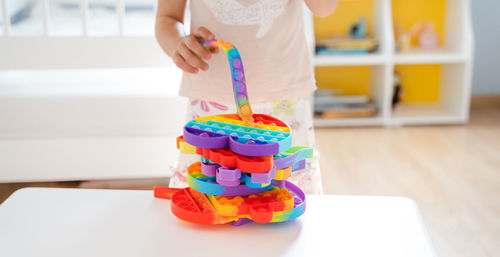 Midsection of child holding multi colored candies