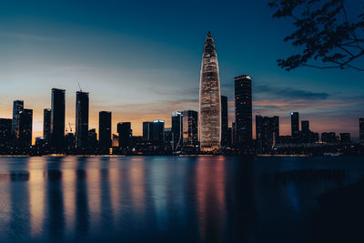 Illuminated buildings in city against sky