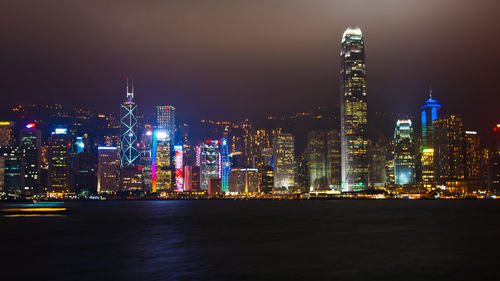 Illuminated buildings in city against sky at night