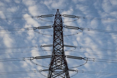 Low angle view of electricity pylon against sky