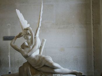 Close-up of angel statue against wall