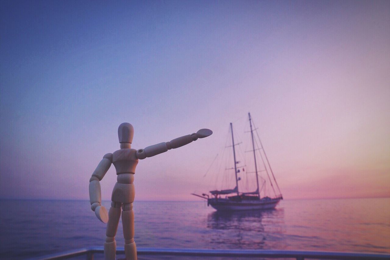 MAN SAILING IN SEA AGAINST CLEAR SKY