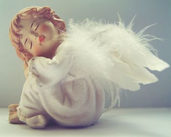 Close-up of angel sculpture over white background