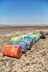 Multi colored umbrellas on sand at beach against clear blue sky