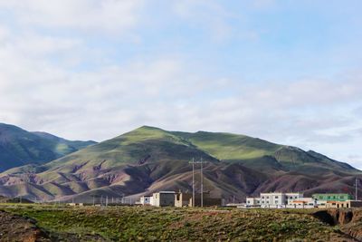 Houses by mountains against sky