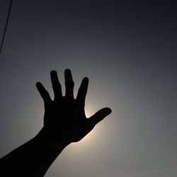 Close-up of silhouette hand against clear sky