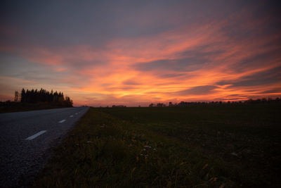 Surface level of road against sky during sunset