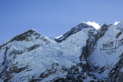 The summit of everest rises behind a ridge near the trail to base camp