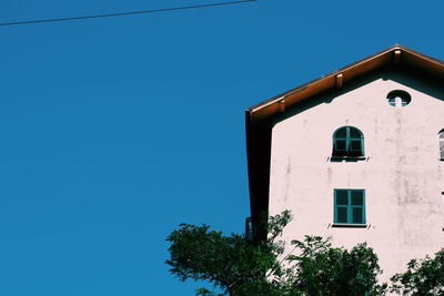 Low angle view of tree and building against clear sky