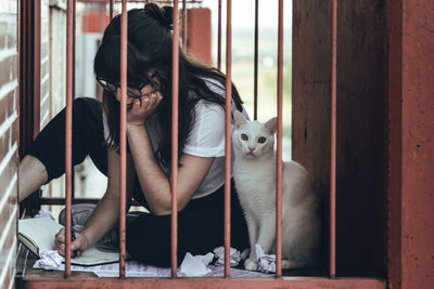 Woman and cat sitting in balcony