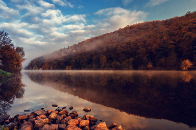 Scenic view of lake by trees against sky