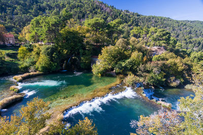 High angle view of river amidst trees against sky