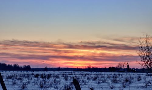 Scenic view of snow field against sky during sunset