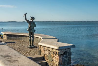 Full length of man standing at sea shore against sky