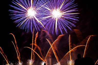 Low angle view of firework display at night